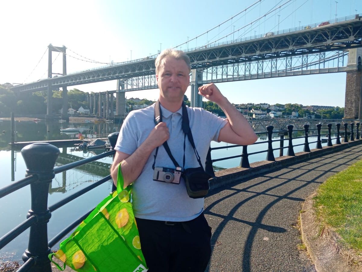 A client out for a sunny walk by the Tamar bridges, camera round his neck